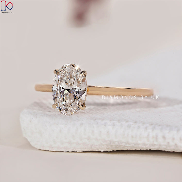 Engagement ring UK featuring an oval shaped engagement ring in yellow gold.
