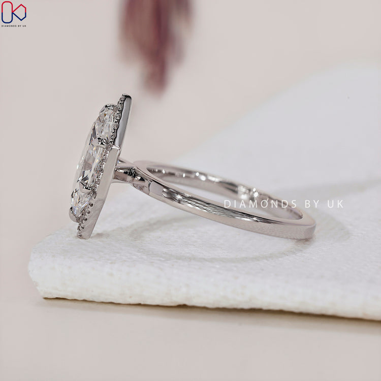 6 prong claw setting with a Dutch Marquise engagement ring and halo diamonds.
