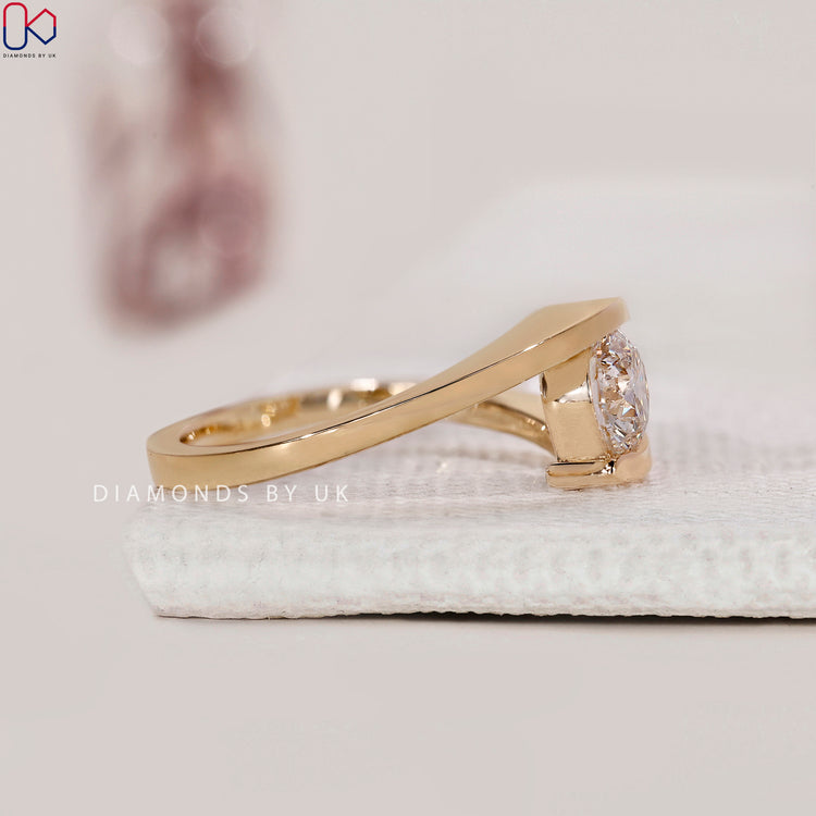 Engagement ring UK design combining classic round cut and creative bypass styling.