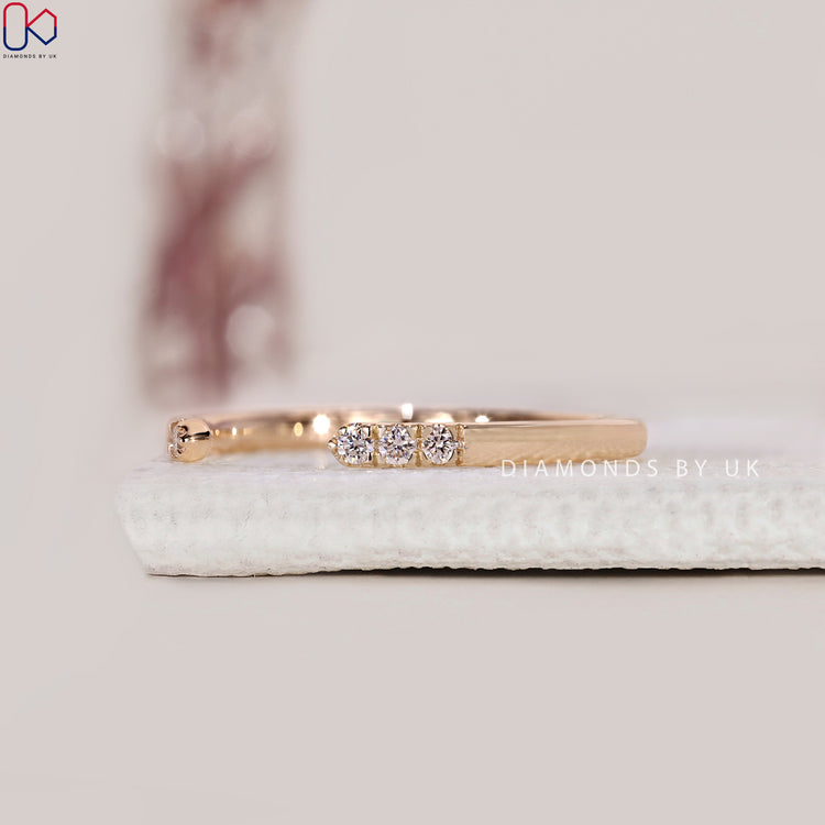 Custom wedding band with open gap and prong set diamond detail.
