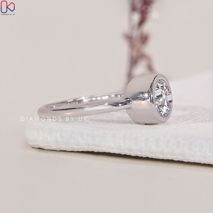 Custom ring featuring a bezel set diamond ring with a radiant round diamond engagement ring.