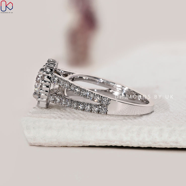 White gold engagement ring with split shank and pave accents.
