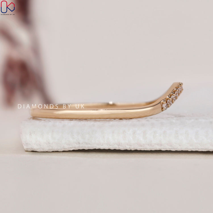Handmade ring featuring a curved wedding band with intricate details.
