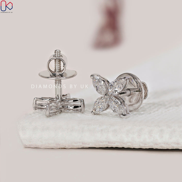 Marquise diamond earrings in prong setting for secure wear.
