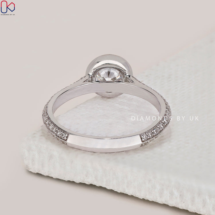 Diamondsbyuk ring with a round diamond and bezel set design.
