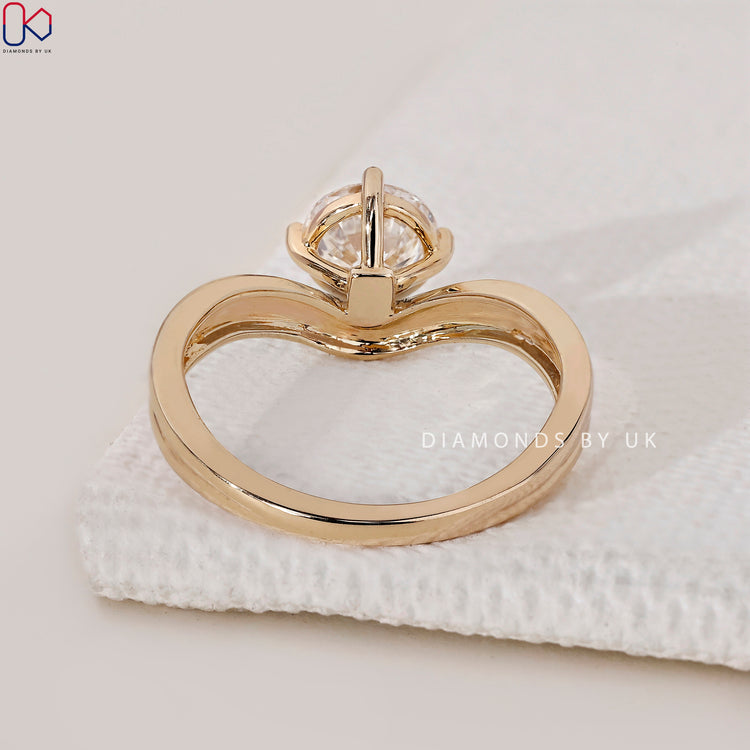 Engagement ring UK featuring a round diamond in yellow gold.
