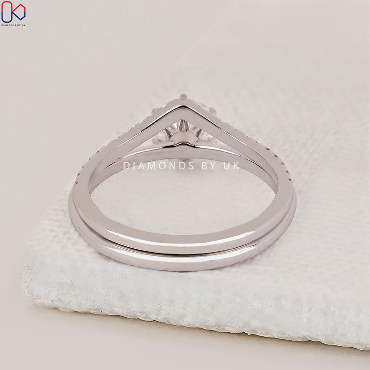 White gold bridal set featuring round cut engagement ring with knife edge shank.
