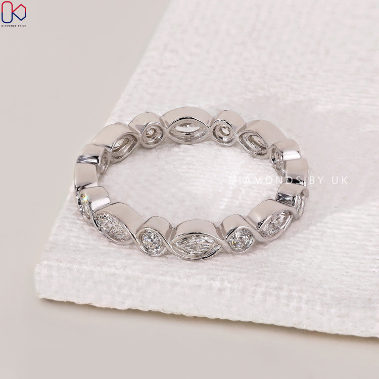 Round diamond wedding band paired with a marquise center stone.
