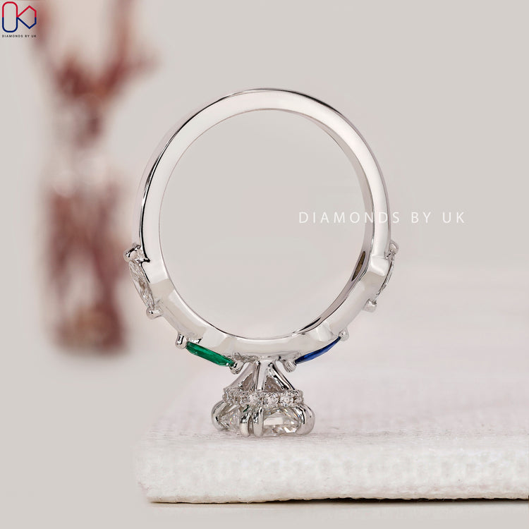 White gold engagement ring with radiant and blue diamonds.
