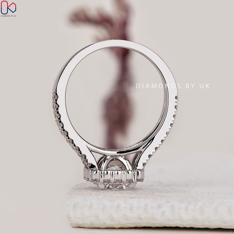 Round halo engagement ring in white gold by Diamondsbyuk.
