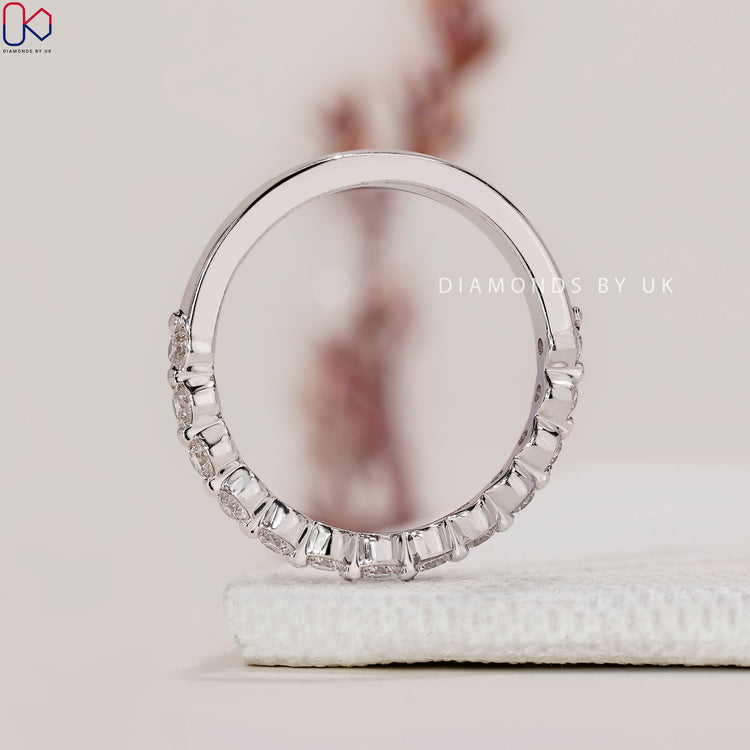A half eternity diamond wedding band by Diamondsbyuk, showcasing exquisite round diamonds.
