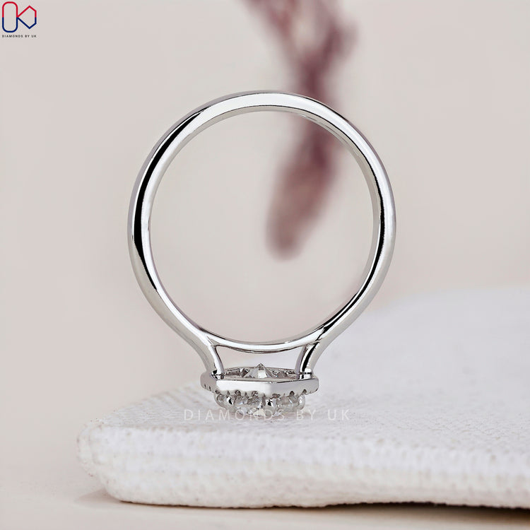 Simple yet elegant halo ring design featuring a round cut diamond.
