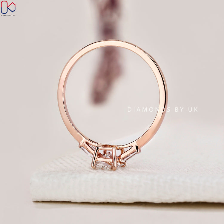 Diamondsbyuk ring showcasing a radiant cut diamond and side stones.
