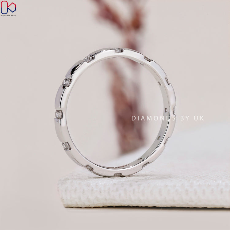 Elegant white gold band with spaced round diamonds.
