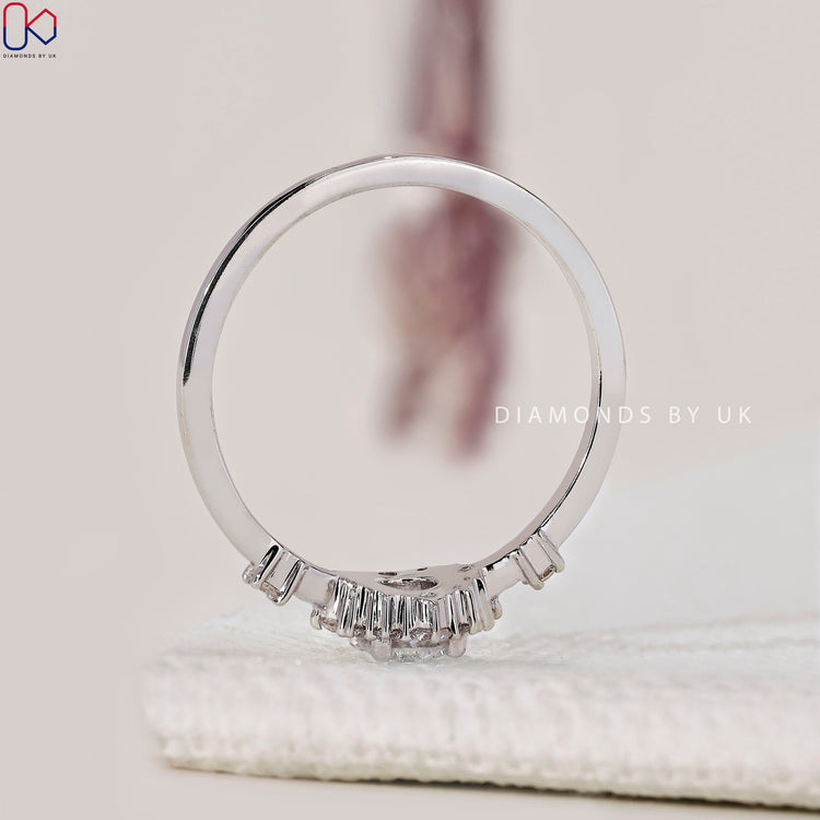 Handmade round diamond engagement ring with side stones in white gold.
