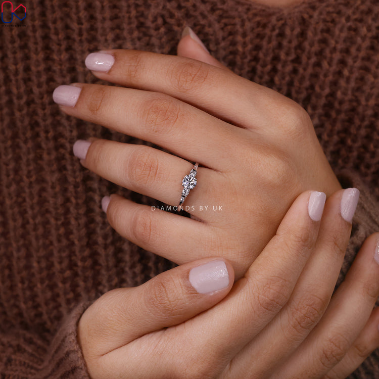 Round and tapered baguette side stone in a detailed band.
