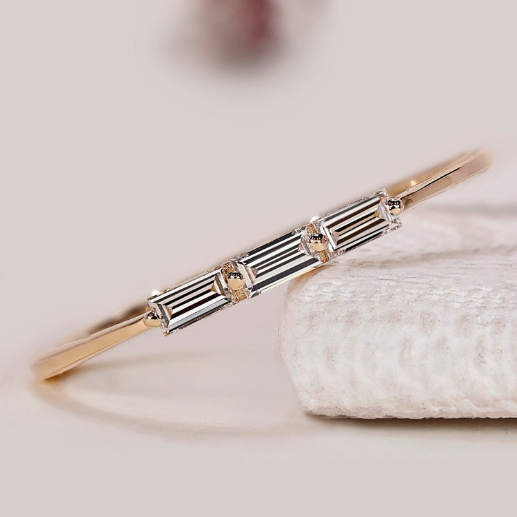 Baguette cut diamond wedding band with three stones.
