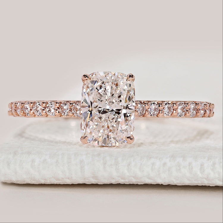 Cushion cut ring with hidden halo and pavé band.
