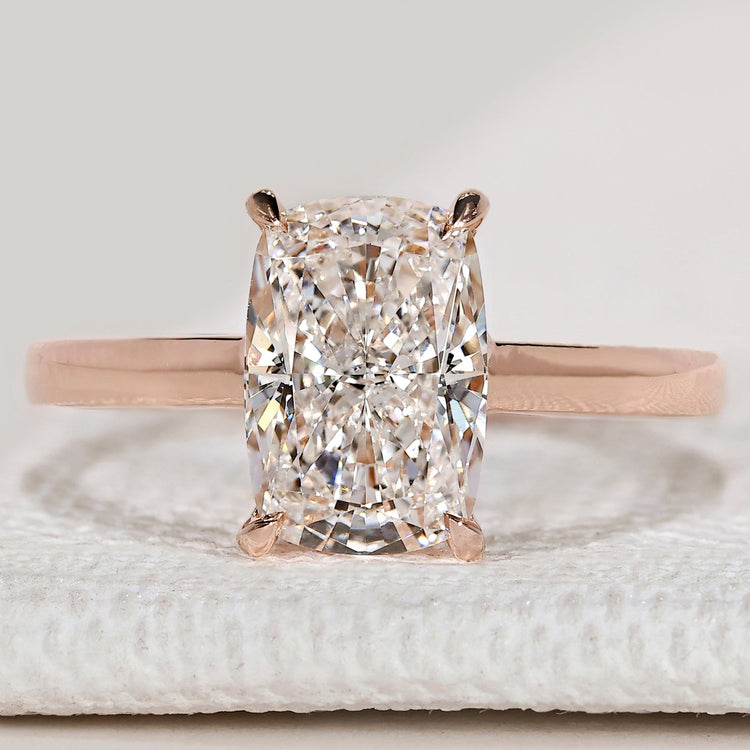 Cushion cut solitaire ring with cathedral setting.