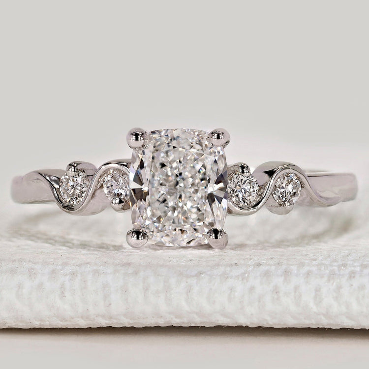 Cushion cut ring with round side stones, five stone.
