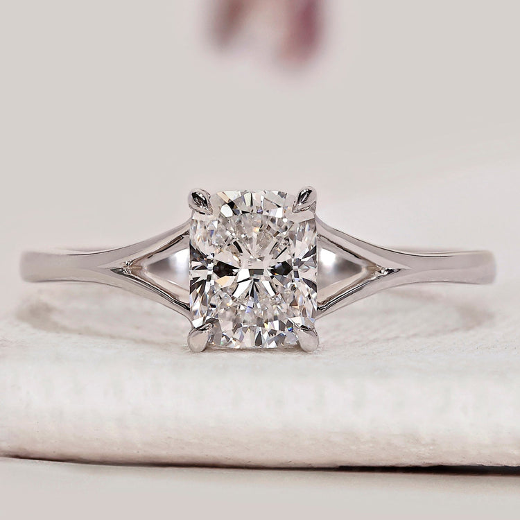 Cushion cut ring with split shank and claw prongs.