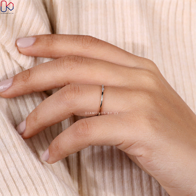 Minimalist wedding band featuring round and marquise stones in a clean design.
