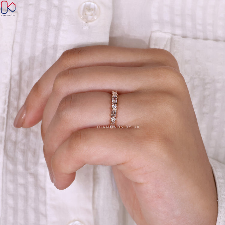 Lab grown diamond band with emerald and round stones.
