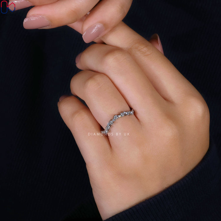 Round cut band with curved style and diamond prongs.