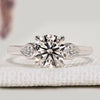 Round cut diamond ring with pear shaped side stones.
