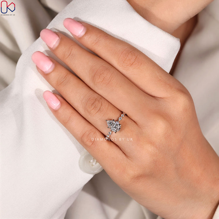 Pear engagement ring with marquise pavé design.