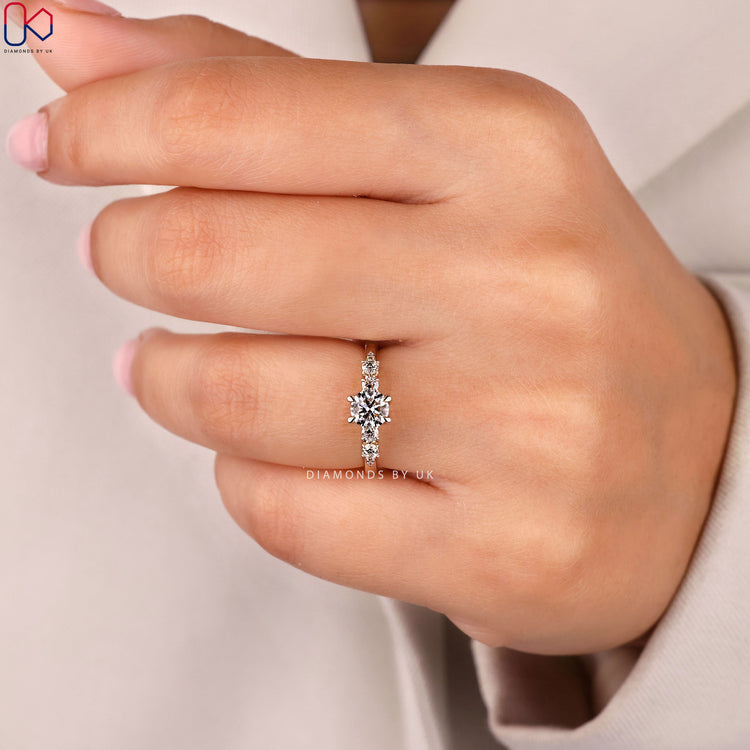 Round cut diamond ring with side stone accents.