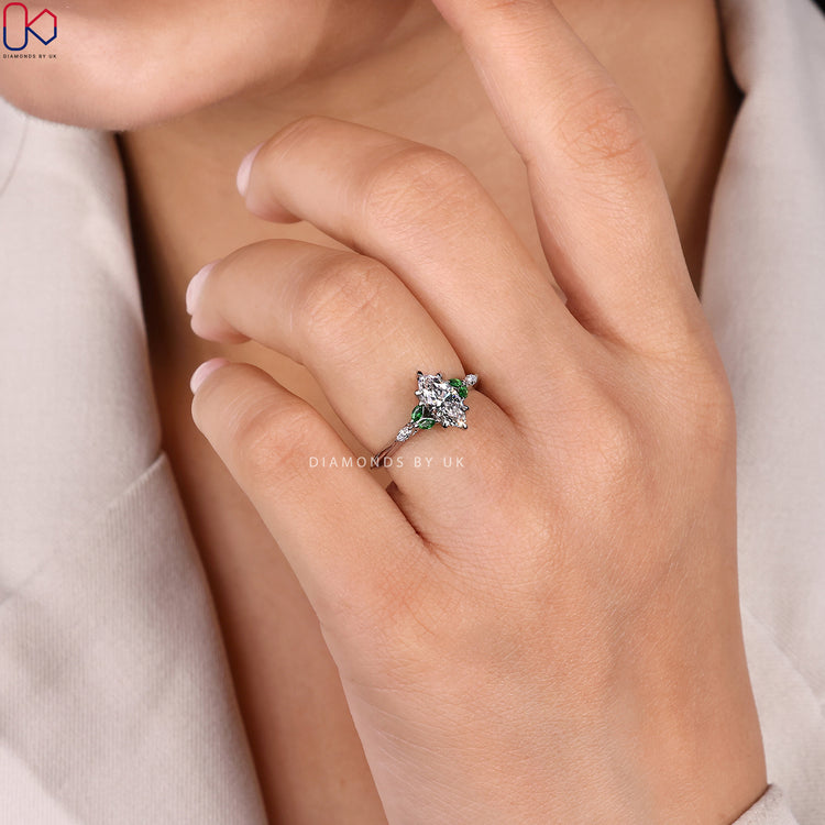 Six claw marquise ring with emerald side stones.