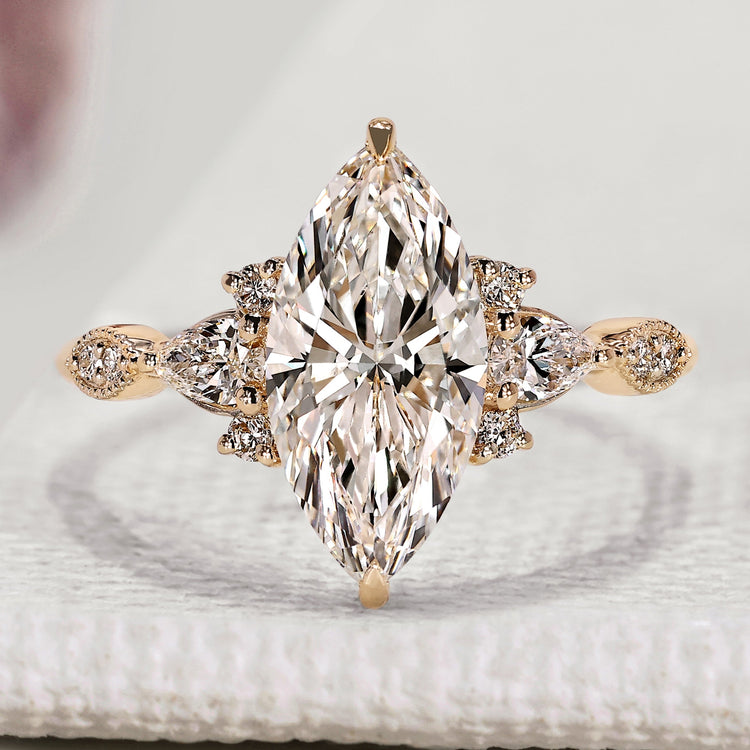 Marquise engagement ring with pear and round side stones.
