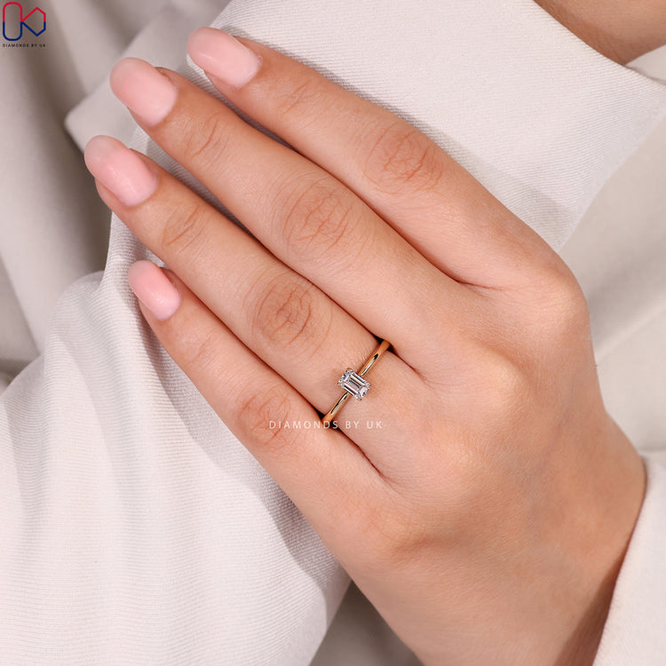 Cathedral emerald cut diamond ring with solitaire style.