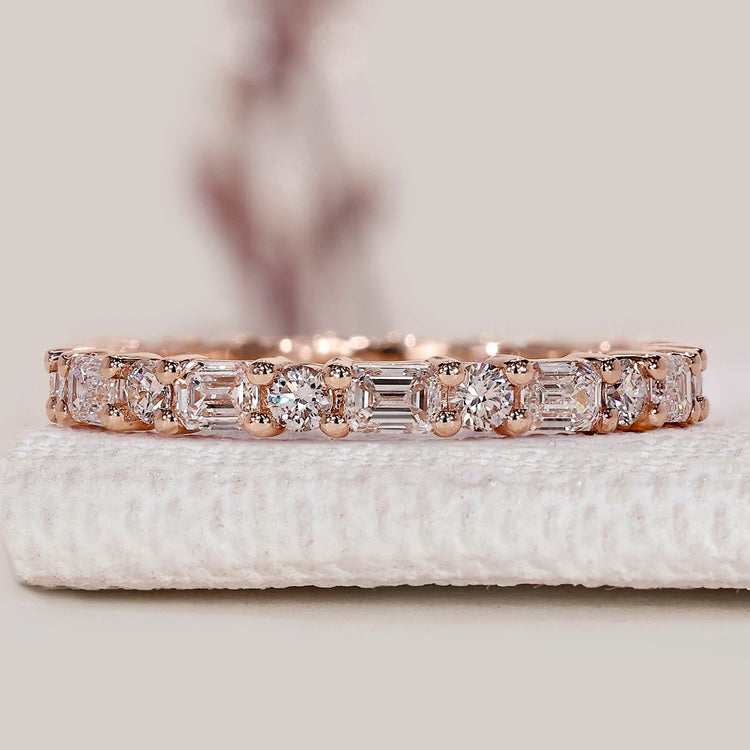 Emerald and round diamond wedding band with prongs.
