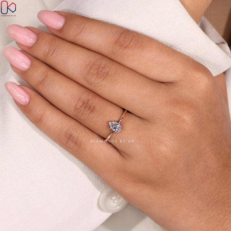 Solitaire pear cut ring with tapered shank band.