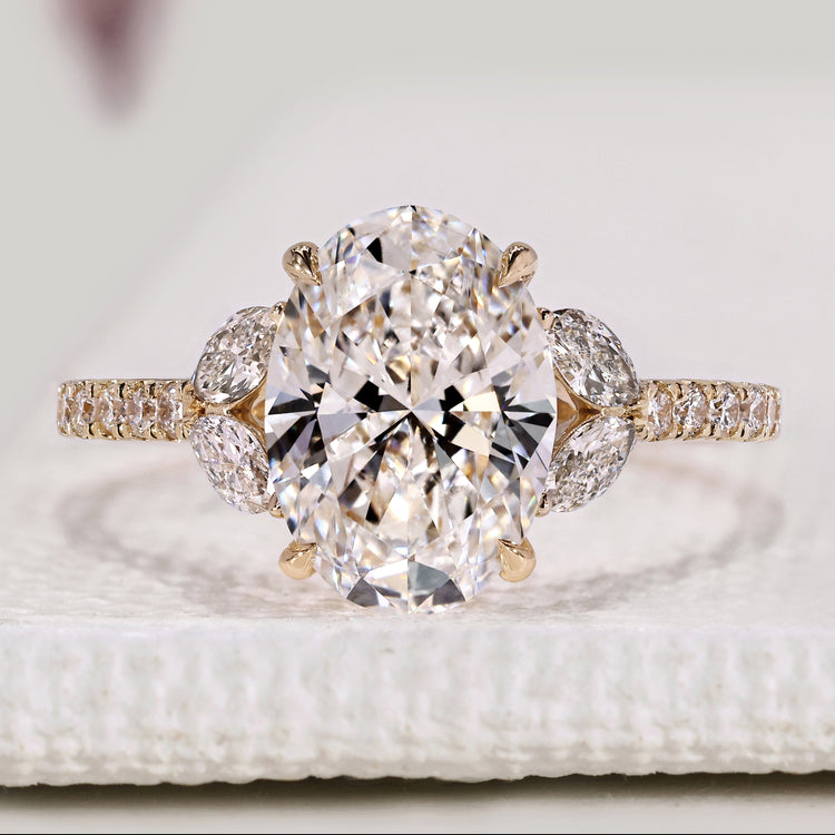Oval diamond engagement ring with marquise side stones.