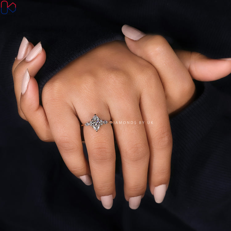 Six claw marquise cut ring with round diamonds.
