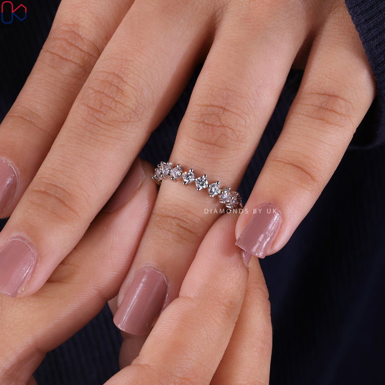 Eternity wedding band with round diamond compass prongs.