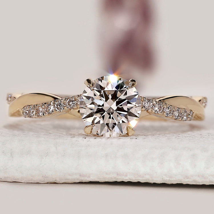 Round diamond engagement ring with twisted pave ring.
