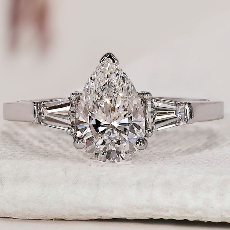 Teardrop diamond ring with tapered baguette side stones.
