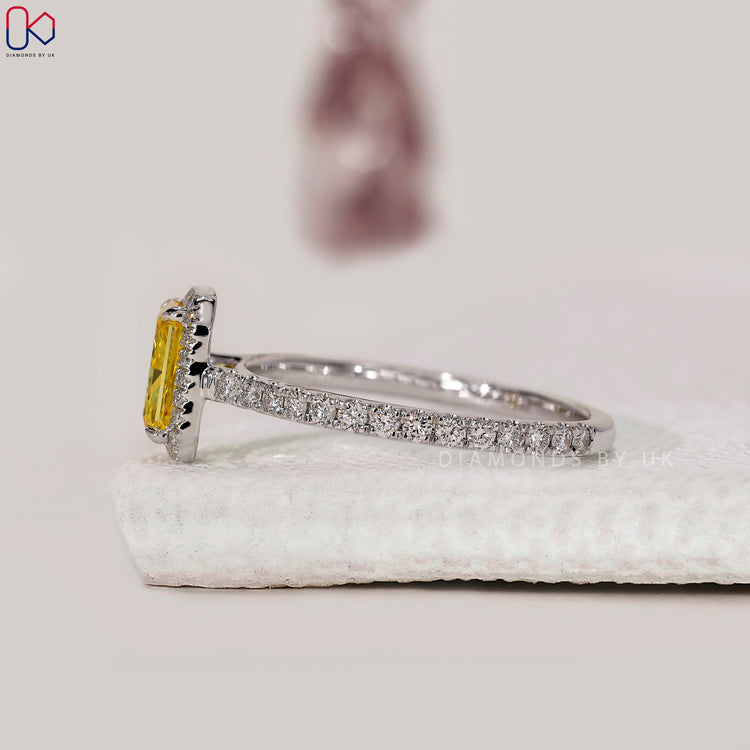 Round cut halo style engagement ring with yellow diamond.
