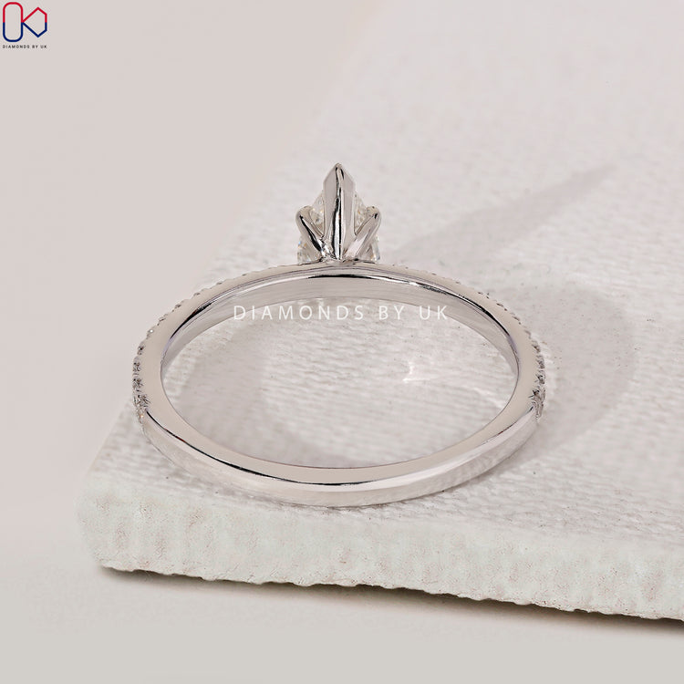 Pear cut engagement ring with pave band detail.
