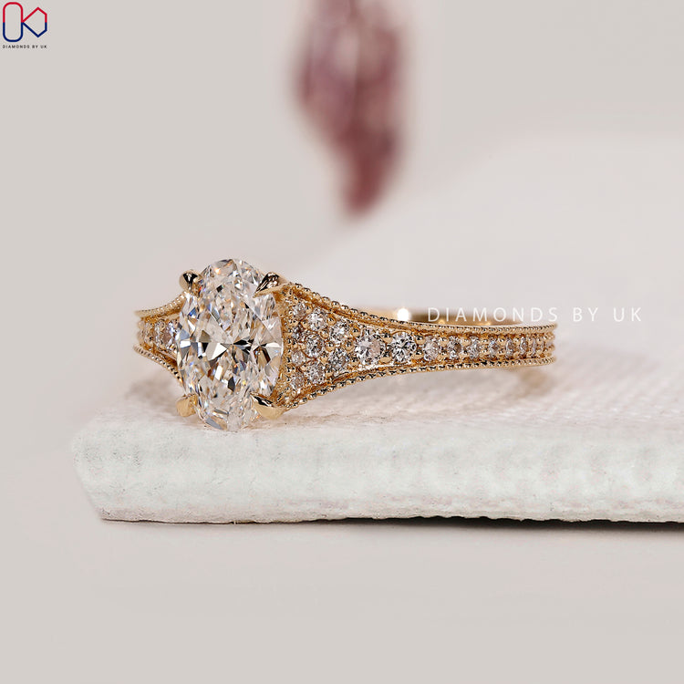 Bridge accent engagement ring with oval center stone.
