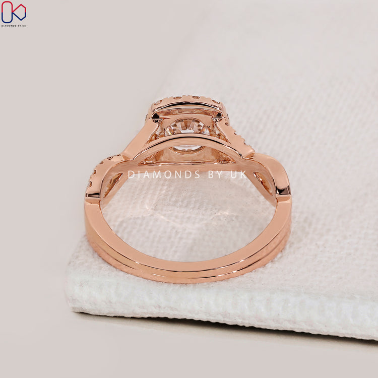 Round diamond ring with halo and twisted shank.
