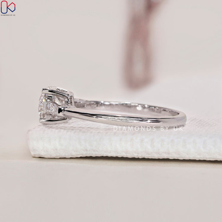 Three stone engagement ring with baguette side stones for extra brilliance and sparkle.