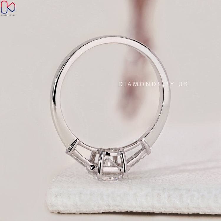 Engagement ring UK design with round cut ring and side stone accents.