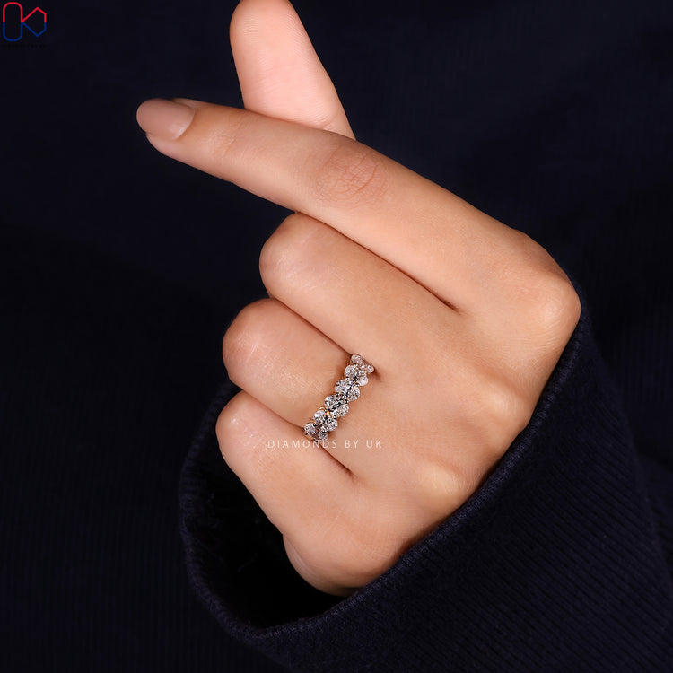 Prong set band with securely held oval stones arranged in a half eternity layout.
