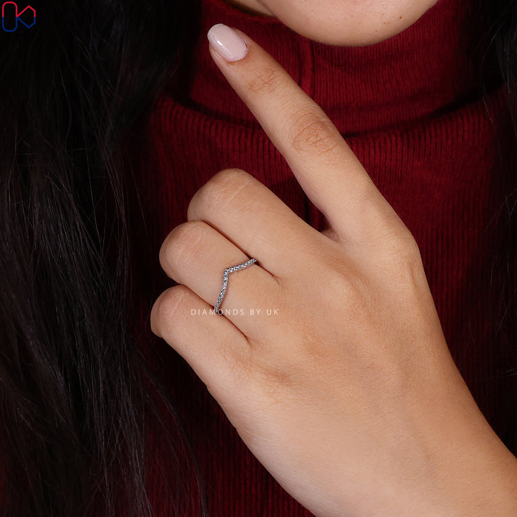 Personalized wedding band designed with a chevron contour and prong set stones.
