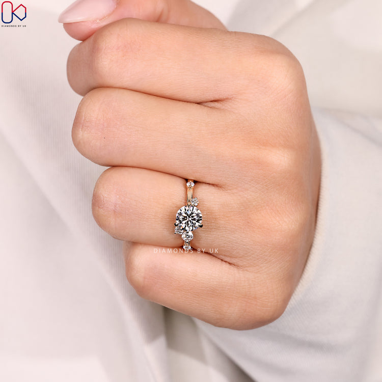 Three claw round diamond ring with cluster setting.